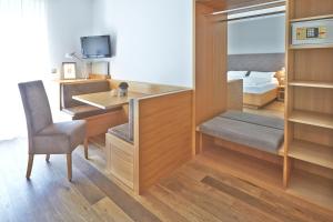 博尔扎诺波斯特葛蕾司酒店的客房设有书桌、椅子和床。