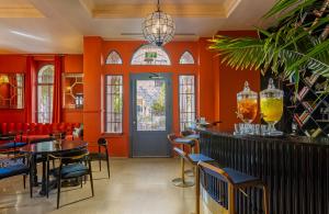 耶路撒冷Villa Brown Moshava - a member of Brown Hotels的餐厅拥有橙色的墙壁和桌椅