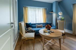 海德堡House of Hütter - Heidelberg Suites & Spa的客厅配有蓝色的沙发和桌子