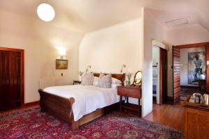 比勒陀利亚布鲁克林庄园酒店的一间卧室配有一张床、一张桌子和一面镜子
