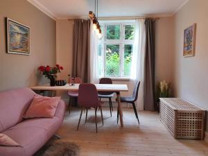 伦讷BoWell apartments with terrace i Rønne的客厅配有粉红色的沙发和桌子
