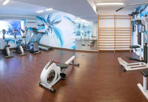 罗列特海岸绿洲公园Spa GHT酒店的健身房设有数台跑步机和有氧运动器材