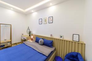 大叻Minh Uyen Homestay的一间卧室配有蓝色的床和一张书桌