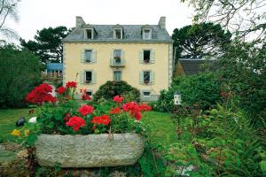 孔卡尔诺Maison de Kersalomon的前面有红花的大房子