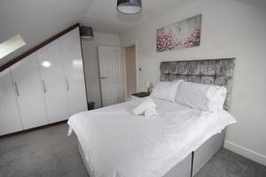 西德雷顿Holden Court Apartment 5的卧室配有白色大床和白色枕头