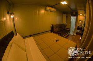 佩尼亚Pousada Costa Container的一间卧室配有一张床和一个沙发