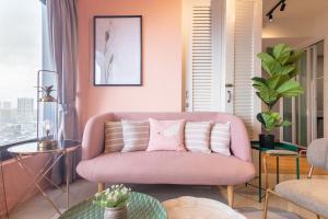 乔治市Georgetown Tropicana 218 by Airlevate Suites的客厅设有粉红色的沙发,配有窗户