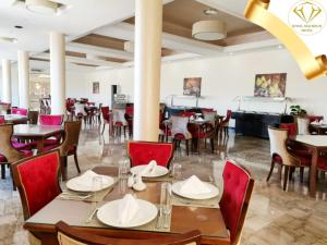 马特鲁港Jewel Matrouh Hotel的一间带桌椅的用餐室和一间酒吧