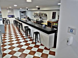桑坦德Pension El Figon的一间设有凳子的酒吧,位于一间设有 ⁇ 面板的餐厅内