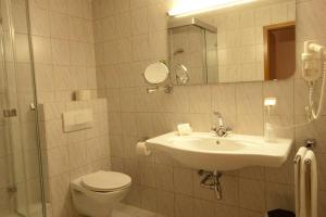 兰施图尔葛丁格酒店的一间带水槽、卫生间和镜子的浴室