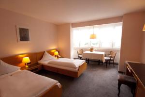 兰施图尔葛丁格酒店的酒店客房设有两张床和一张桌子。
