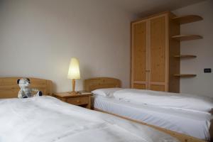 戴亚诺米拉梦地公寓式酒店的一间卧室设有两张床,床头柜上摆放着泰迪熊