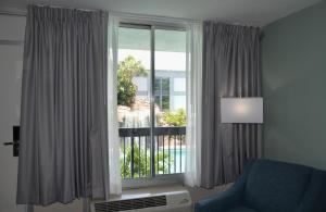 奥兰多Opal Hotel & Suites的客厅设有窗户和蓝椅