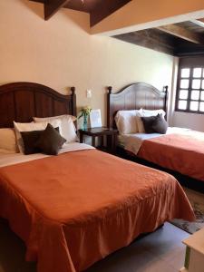 坎昆皮凯里住宿加早餐旅馆的一间卧室配有两张带橙色棉被的床
