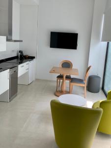 塞维利亚Apartamentos Rivero 8的客厅配有桌子和绿色椅子