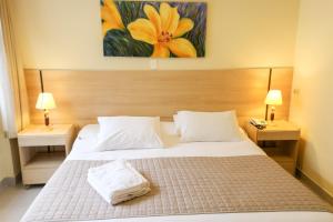 雷森迪River Park Hotel的一间卧室配有一张带2个床头柜和2盏灯的床。