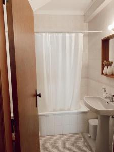 圣佩罗德姆Casa dos Pinheiros的浴室配有淋浴帘和盥洗盆。