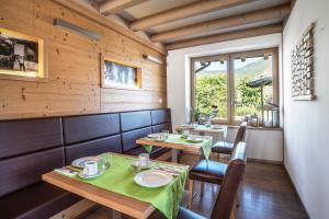 特伦托阿尔曼尼埃罗农家乐的餐厅设有2张桌子和椅子以及窗户。