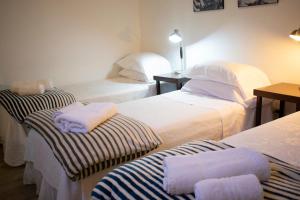 布宜诺斯艾利斯BA STOP旅社的一间设有三张床的客房,备有毛巾