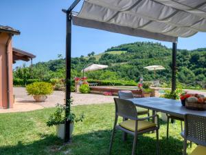 乌尔比诺Belvilla by OYO Villa Angolo Fiorito的院子里伞下的桌子和椅子