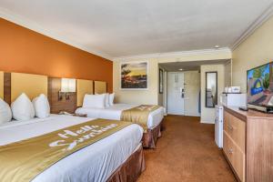 棕榈泉棕榈泉戴斯酒店的酒店客房设有两张床和一台平面电视。