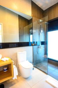 Loloata IslandLoloata Island Resort的一间带卫生间和玻璃淋浴间的浴室