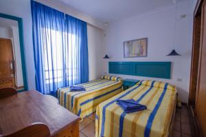 卡门港阿瓜码头公寓酒店的酒店客房设有两张床和一张桌子。