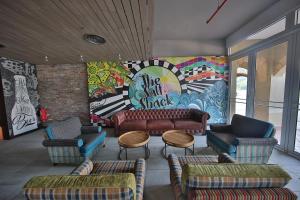 珍南海滩兰卡威世界度假村的大堂配有沙发、椅子和壁画