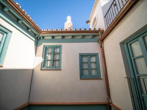 塞维利亚Casas de Sevilla - Apartamentos Vidrio 7的拥有蓝色窗户和阳台的建筑