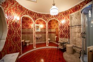 Palo del ColleB&B Savarini的浴室拥有红色和金色的壁纸,设有卫生间