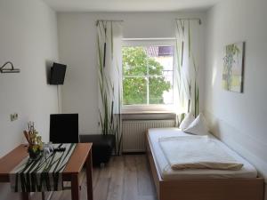 MindelstettenLandgasthof Braun的客房设有床、桌子和窗户。