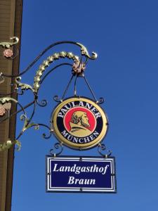 MindelstettenLandgasthof Braun的挂在建筑物上的兰开夏尔公司标志