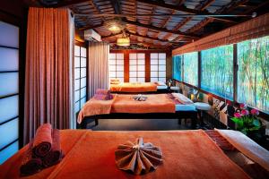 胡志明市Silverland Sakyo Hotel的一间卧室配有两张带橙色床单的床
