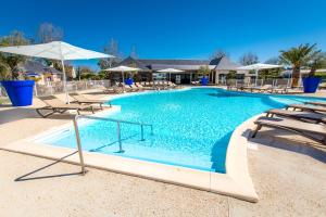 Langrune-sur-MerM&V Resort Camping的一个带椅子和遮阳伞的大型游泳池