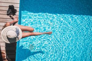 拉古多阿姆索奈可酒店的身着帽子的女人,躺在游泳池边