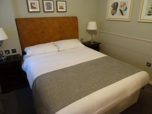 塞尔The Belmore的一间卧室配有一张带白色床单的大床