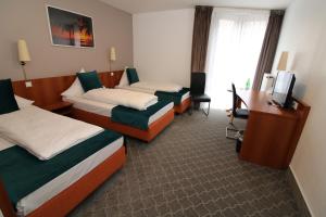杜塞尔多夫阿斯科特康恩得酒店的酒店客房配有两张床和一张书桌