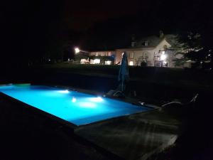 Saint-Paul-de-JarratLe Clos Cathala Chambres d'Hôtes的夜晚的游泳池,灯光蓝色