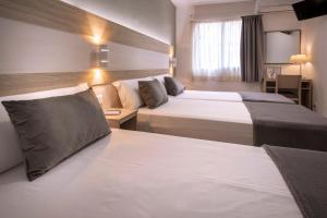 塔拉戈纳Hotel Catalunya Express的酒店客房配有两张床和一张书桌