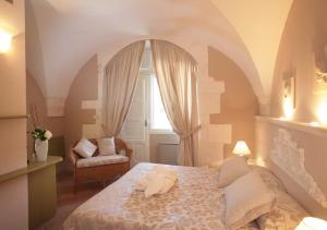 奥斯图尼诺维切托公园度假酒店的一间卧室设有一张床、一个窗口和一把椅子