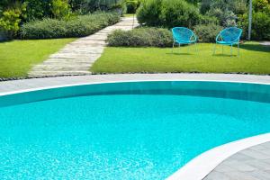 埃尔科拉诺Maison Di Fiore B&B的两把蓝色椅子坐在游泳池旁