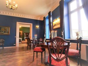 Hohen DemzinSchlosshotel Gross Koethel的一间拥有蓝色墙壁和桌椅的用餐室