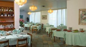 索威拉托玛里纳Hotel Nettuno的餐厅配有桌椅和白色的桌布