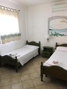 巴哈撒丁岛Vallemare Residence e Studios的一间卧室设有两张床、一个窗口和镜子