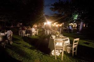 杰拉拉廖Cascina Borgofrancone的一群桌子和椅子在草地上过夜