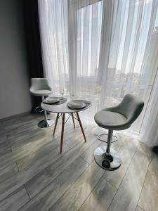 敖德萨Arcadia Luxe SeaView Apartment的一间设有两张桌子、一把椅子和一个窗户的房间