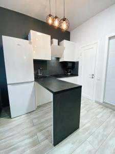 敖德萨Arcadia Luxe SeaView Apartment的厨房配有白色家电和黑色台面
