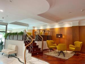 圣地亚哥－德孔波斯特拉康姆波斯特拉苏伊德酒店的一间设有黄色椅子和楼梯的等候室