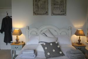 巴斯隆德希尔住宿加早餐旅馆的卧室配有带枕头和两盏灯的白色床。