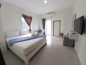 素叻帕庞孔公寓的白色卧室设有一张大床和电视。